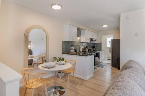 een keuken en een woonkamer met een tafel en stoelen bij NEW! Comfy 1 Bedroom Flat I Hollywood Suites in Mount Clemens