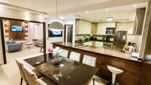 a kitchen and living room with a table and chairs at Linda Casa em Santa Felicidade in Curitiba