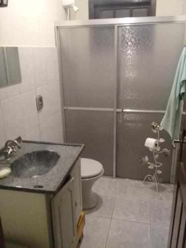 W łazience znajduje się prysznic, umywalka i toaleta. w obiekcie Casa Ampla w mieście Passa Quatro