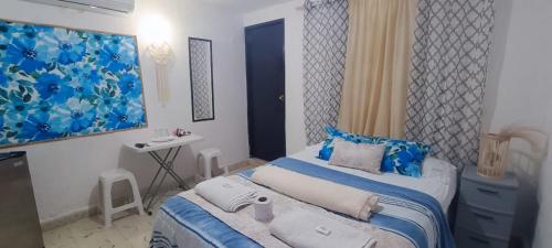 a bedroom with a bed with blue and white sheets at Casa Calis Cancún in Cancún