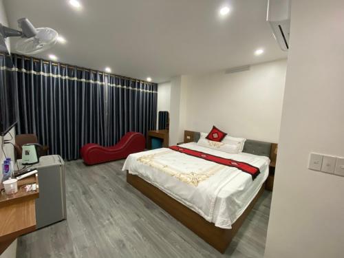 1 dormitorio con 1 cama y 1 silla roja en Toàn Phát Hotel en Bắc Quang