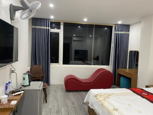 1 dormitorio con una silla roja frente a una ventana en Toàn Phát Hotel en Bắc Quang