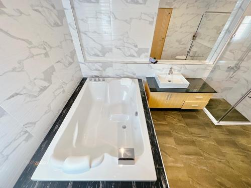 a bathroom with a bath tub and a sink at Rosewood Pool Villa Pattaya 3 in Pattaya South