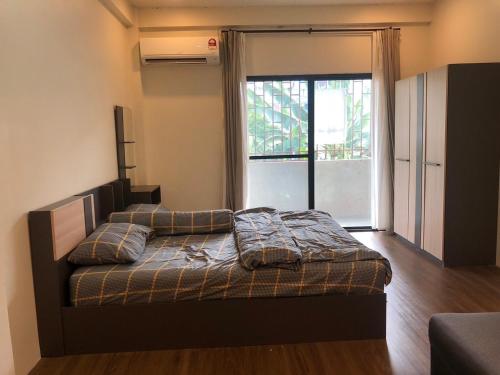 a bedroom with a bed with pillows and a window at ONYX Café & Hostel in Betong