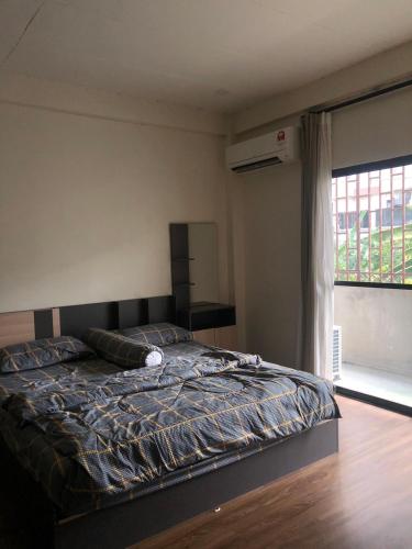 1 dormitorio con cama y ventana grande en ONYX Café & Hostel, en Betong