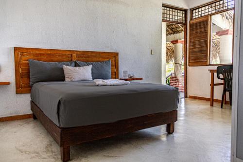 ein Schlafzimmer mit einem großen Bett mit einem hölzernen Kopfteil in der Unterkunft Hotel Manava in Brisas de Zicatela