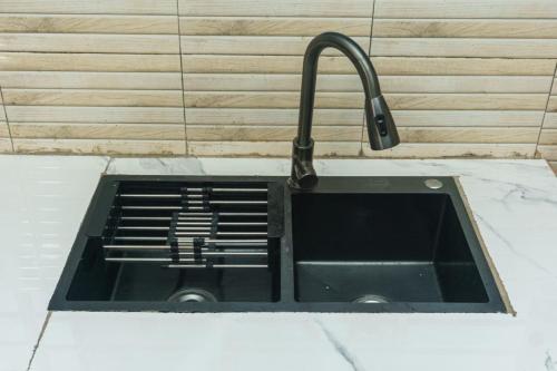 eine Küchenspüle mit einem Wasserhahn auf der Theke in der Unterkunft Mountain view apartment 