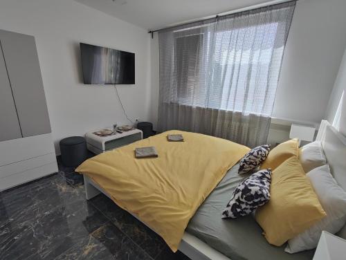 - une chambre avec un lit doté de draps jaunes et une fenêtre dans l'établissement Súkromný luxusný apartmán, à Hlohovec