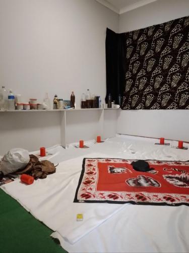 ein Zimmer mit einem Bett mit einem Teppich darauf in der Unterkunft The Best African Traditional Healer and Love Spell sangoma in Polokwane in Polokwane