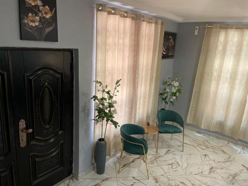 a room with two chairs and a table and a door at Luxury Townhome in Oyarifa in Oyarifa