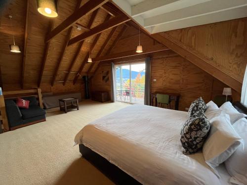 una camera da letto con un letto grande e una grande finestra di Captain Moonlight Cottage a Mount Beauty