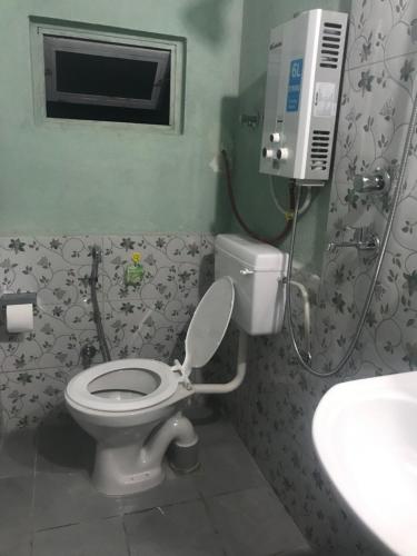 Sunrise Point Homestay في ناغاركوت: حمام به مرحاض أبيض ومغسلة