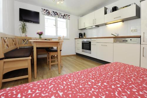 a kitchen with a desk and a table in a room at Aktiv-Ferienwohnungen Montafon in Sankt Gallenkirch