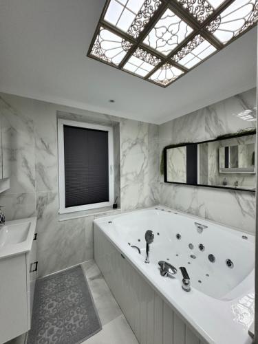 a large white bath tub in a bathroom with a window at White house ( Beyaz ev ) in Foça