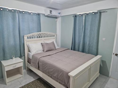- une chambre dotée d'un lit avec des murs et des rideaux bleus dans l'établissement mountain view apartment 2, à Roseau