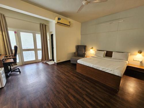 a bedroom with a bed and a desk and a chair at Andheri Sports Complex - VIP Guest House in Mumbai