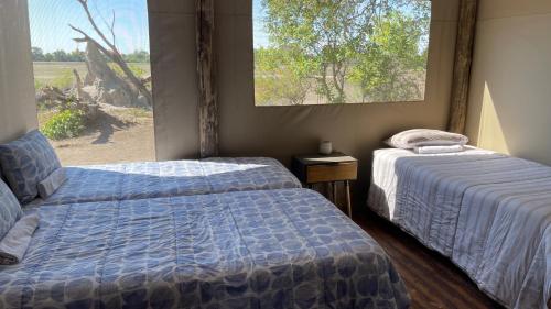 2 Betten in einem Zimmer mit Fenster in der Unterkunft Hippo Lagoon Cabin in Ntabis