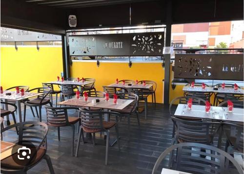 een restaurant met tafels en stoelen en een gele muur bij T3 ISIS APPART - Quartier Hauts Vallons in Mamoudzou