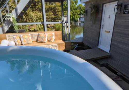 a hot tub on the patio of a house at Tulana Taggs - floating home on idyllic island in Hampton Hill