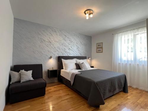 a bedroom with a bed and a chair at Villa Milina Korčula in Vela Luka