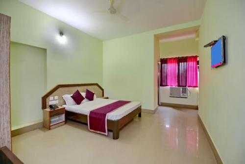 a bedroom with a bed and a window at Goroomgo Dittu Holiday inn puri-Near Nilandri Beach-Best Experince Ever in Puri