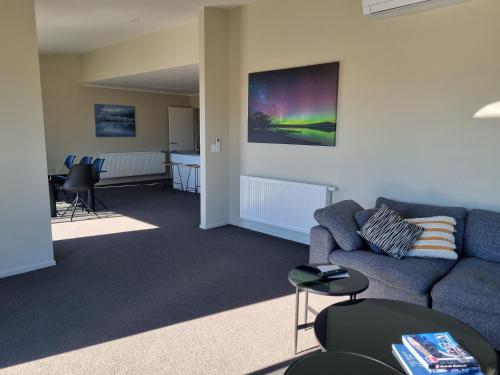 a living room with a blue couch and chairs at Ben Ohau Views On The Drive in Twizel