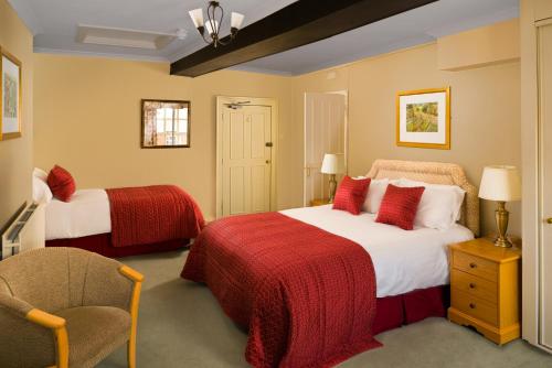 a hotel room with two beds and a chair at Marlborough Arms in Woodstock