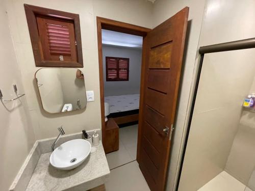 a bathroom with a sink and a mirror at Refúgio em Carneiros in Tamandaré