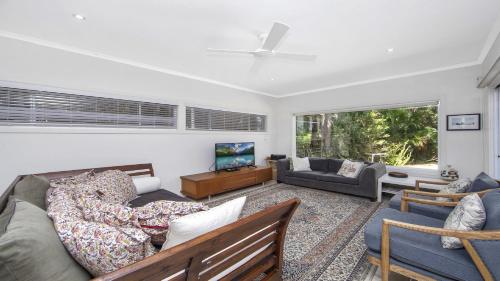 a living room with a couch and a tv at Your Beach House in Pearl Beach
