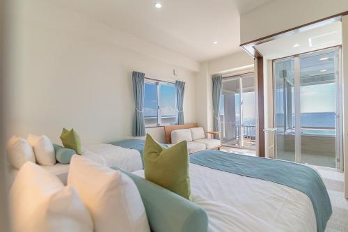 two beds in a room with a view of the ocean at Seven Colors Ishigakijima in Ishigaki Island