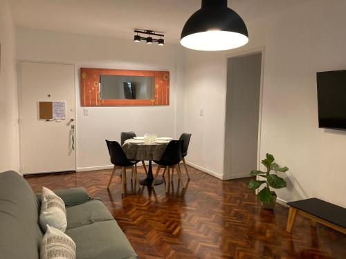 ein Wohnzimmer mit einer Couch und einem Tisch mit Stühlen in der Unterkunft Excelente ubicación y comodidad in Buenos Aires