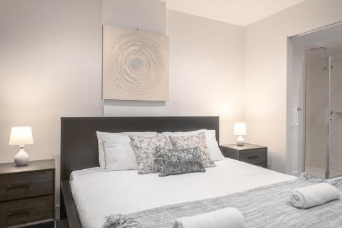 a bedroom with a large white bed with pillows at 2br2ba Apartment Cbd Great Viewspoolgym in Melbourne