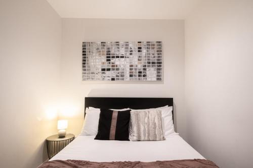 a bedroom with a bed with a picture on the wall at 2br2ba Apartment Cbd Great Viewspoolgym in Melbourne