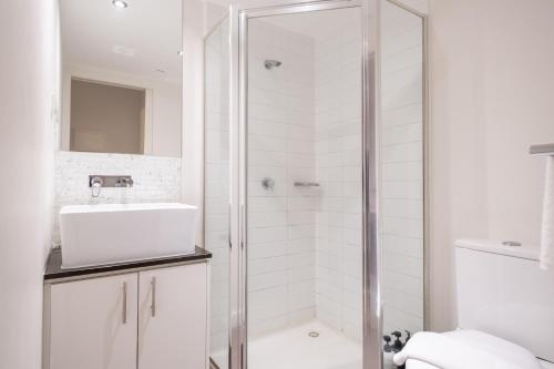 a white bathroom with a shower and a sink at 2br2ba Apartment Cbd Great Viewspoolgym in Melbourne