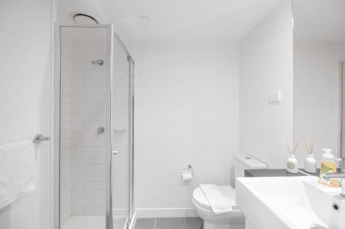a white bathroom with a shower and a toilet at 2br2ba Apartment Cbd Great Viewspoolgym in Melbourne