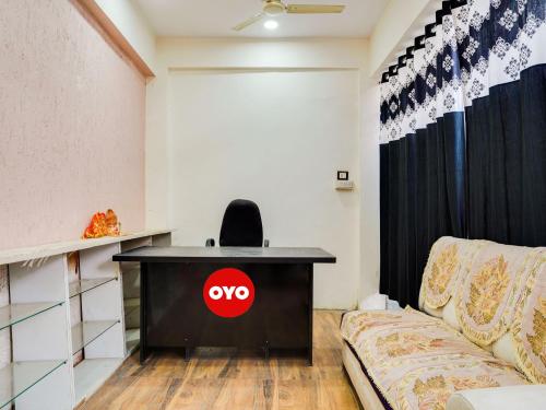 una scrivania con sopra un cartello aortico accanto a un divano di OYO Hotel Shivansh a Bhopal