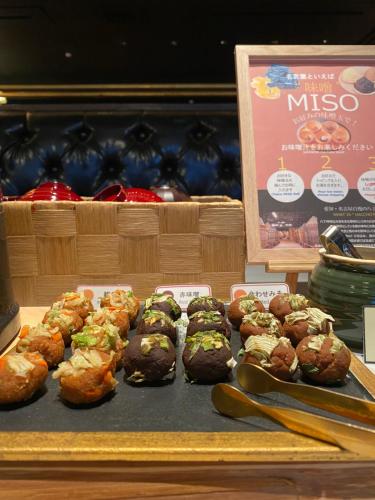 a display case with a bunch of donuts on a table at Hotel Silk Tree Nagoya in Nagoya