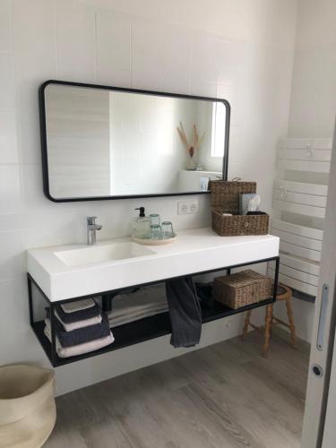 een badkamer met een witte wastafel en een spiegel bij Villa les 3 lumières 8-10 personnes, Clim, piscine à proximité des plages in La Ciotat