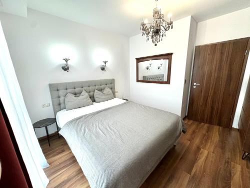 Schlafzimmer mit einem Bett und einem Kronleuchter in der Unterkunft Firenze Apartment in Timişoara