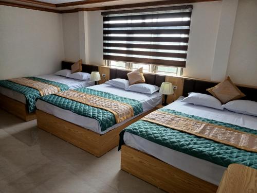 two beds in a room with a window at Quan Lan Nam Phong Hotel in Quan Lạn