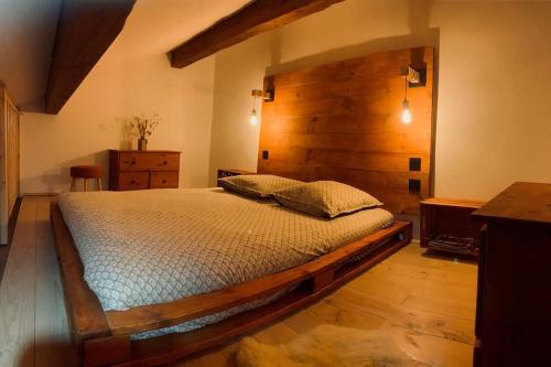 a bedroom with a large bed with a wooden wall at Orcières Merlette - Haut Champsaur, classé 3* in Orcières