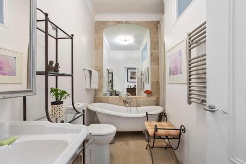 y baño con bañera, aseo y lavamanos. en Unique sea view apartment, center, 100m2 en Niza