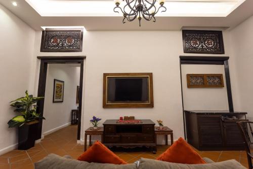 a living room with a couch and a tv at Hotel Puri Melaka in Malacca
