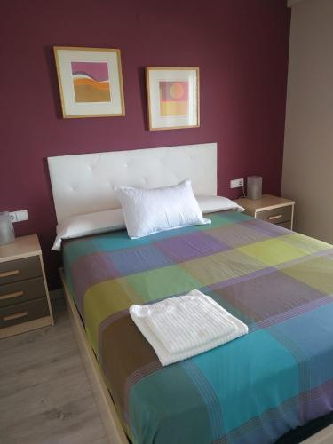 a bedroom with a colorful bed with two night stands at Desconexión y Relax in Mareny Blau