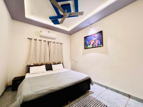 a bedroom with a bed and a ceiling fan at Kailashbhavan Oasis - Full Villa By AP Villas in Ujjain