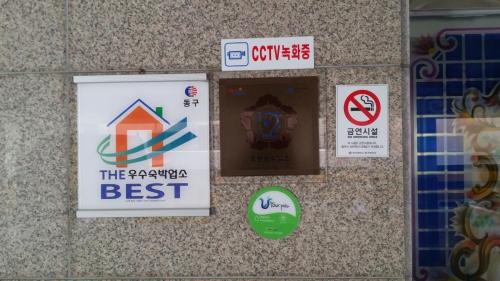 a sign on a wall with signs on it at Plus Motel in Busan