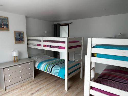 a bedroom with two bunk beds and a desk at Cap à la mer in Sangatte