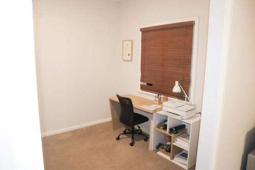 an office with a desk with a chair and a window at Home in Lamington in Kalgoorlie