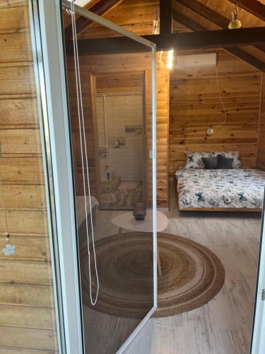 eine Glastür eines Zimmers mit einem Bett in der Unterkunft Cabana Sorina in Corbu