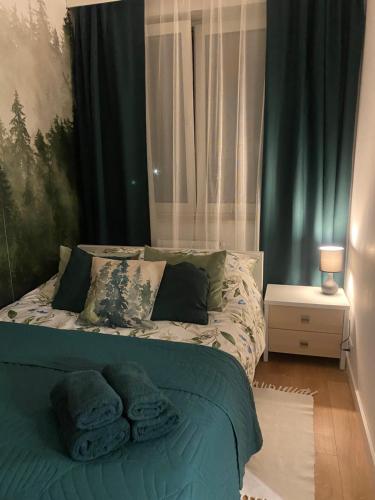 a bedroom with a bed with towels on it at Chillout Airport Apartment KL33 - Free parking in Warsaw